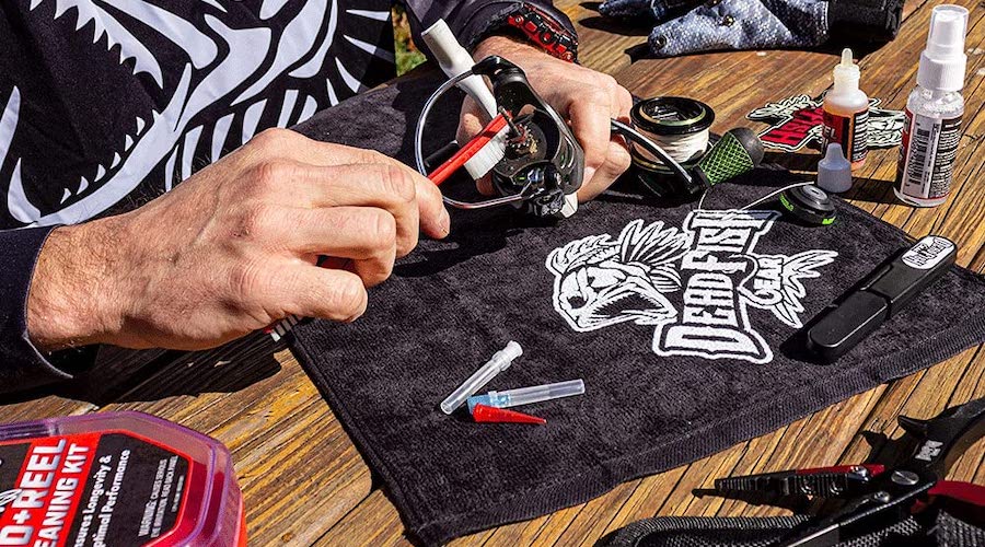 The person using the DeadFish Gear Rod and Reel Care Kit to clean their fishing gear.