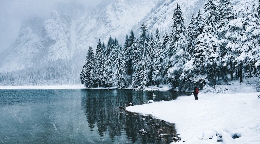 A person walking alongside a lake in the wintertime.
